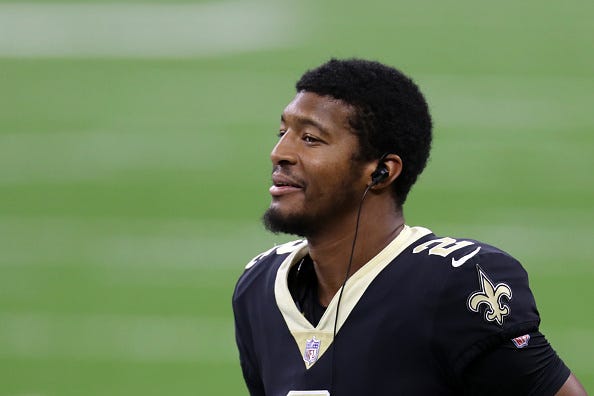 Jameis Winston smiles on the sideline with the New Orleans Saints. 