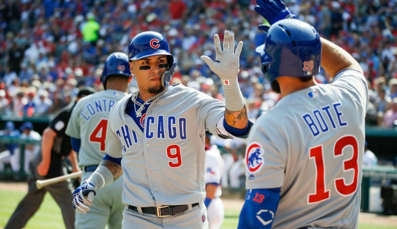 Cubs shortstop Javier Baez (9) is greeted at the dugout by third baseman David Bote (13) after hitting a solo home run. 