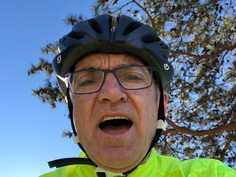 John riding a bike and smiling