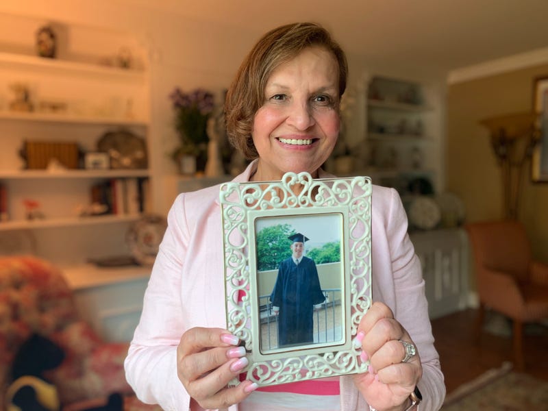 Judi Reiss holds a picture of her son, Josh, on his graduation day.