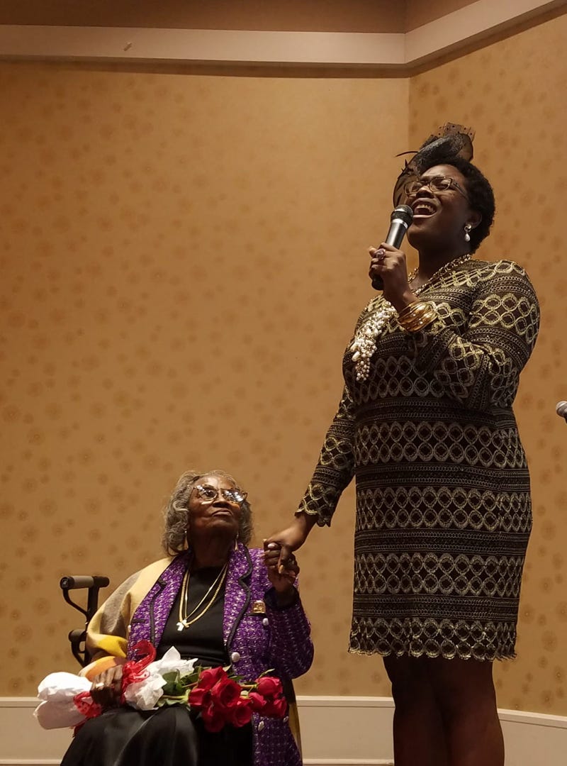 Mrs. Juanita Abernathy is serenaded by singer Nia Sadé Akinyemi during an awards ceremony in February 2019