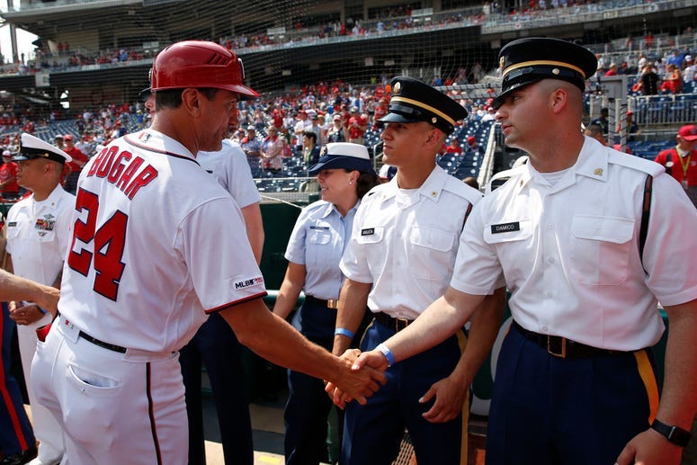 Nationals First Base Coach Tim Bogar greets military members honored before the game