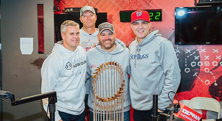The Sports Junkies pose with the Commissioner's Trophy