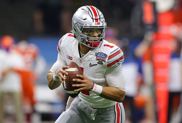 Ohio State QB Justin Fields rolls out of the pocket while looking for a receiver. 