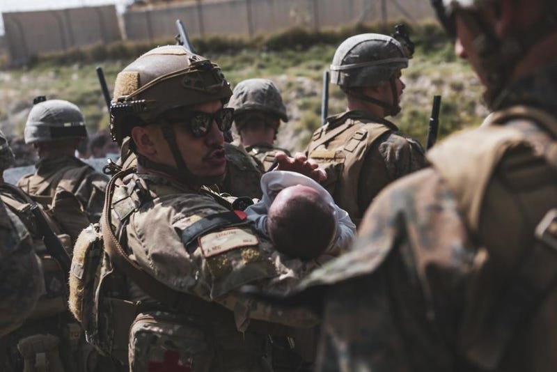 An Airmen comforts an infant