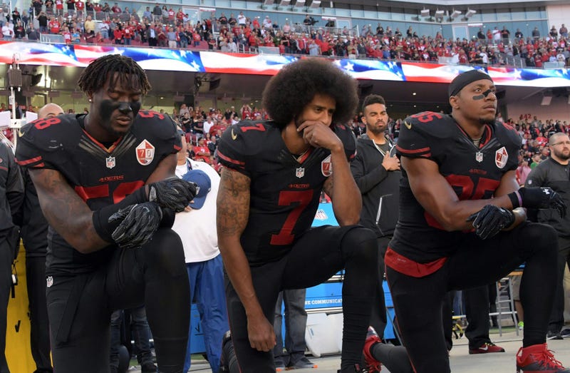 49ers outside linebacker Eli Harold (58), quarterback Colin Kaepernick (7) and safety Eric Reid (35) kneel in protest during the national anthem before a game in 2016.