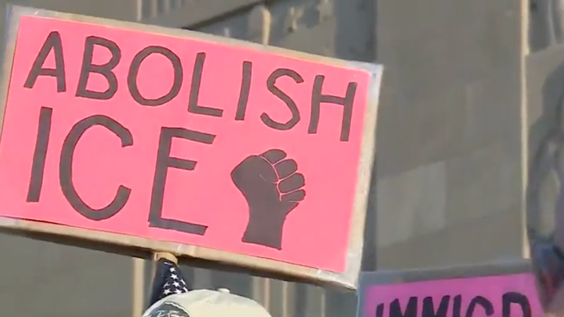 A demonstrator holds a sign during protest that reads "abolish ICE"