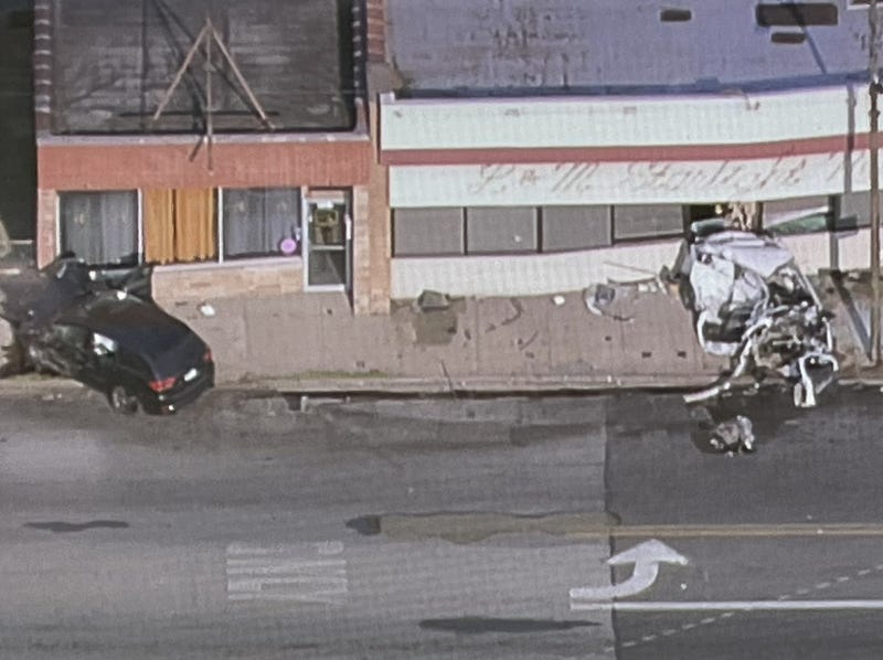 crash sceen involving damaged black SUV and totaled white sedan