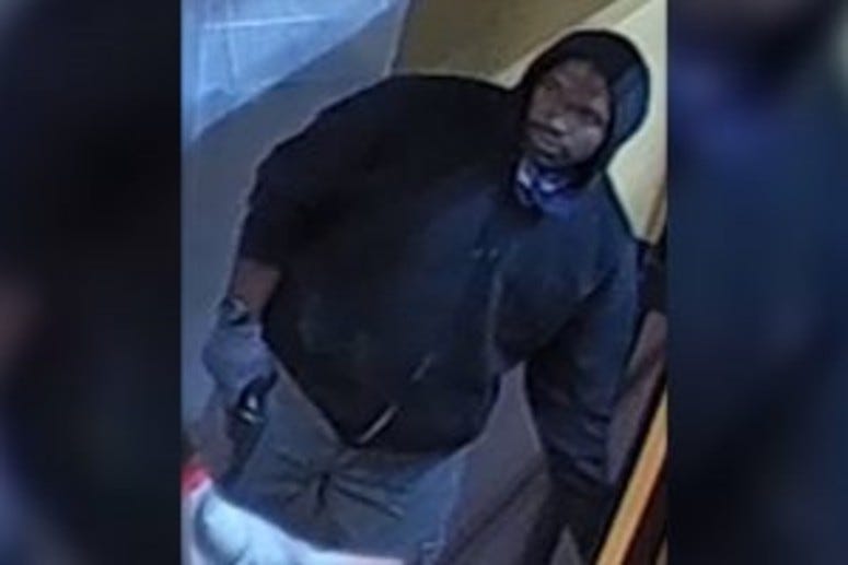 A surveillance photo taken during the homicide of a Dunkin' Donuts worker in Philadelphia. A man charged in this case has also been charged with his mother's death.