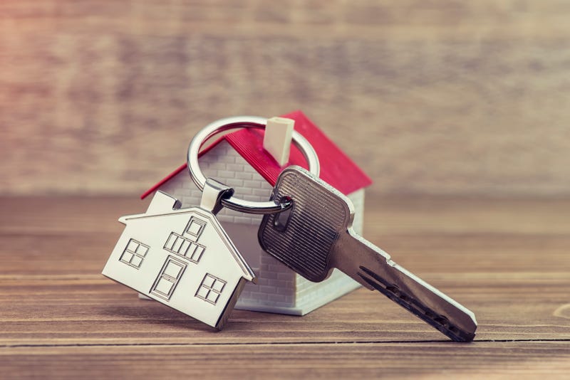 House key and key chain on wooden table
