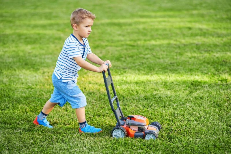 kid mowing grass