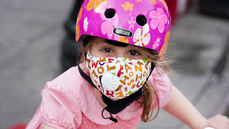 A child wearing a protective mask waits outside Lenox Hill Hospital to show gratitude to the medical staff during the coronavirus pandemic on May 15, 2020 in New York City.