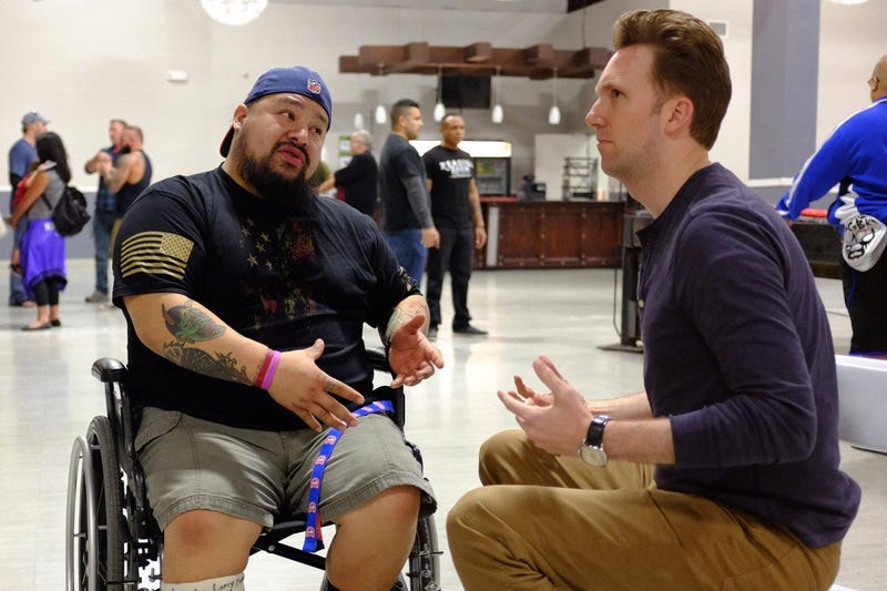Host Jordan Klepper (right) speaks with a vet at a Valhalla Club event in Killeen, Texas