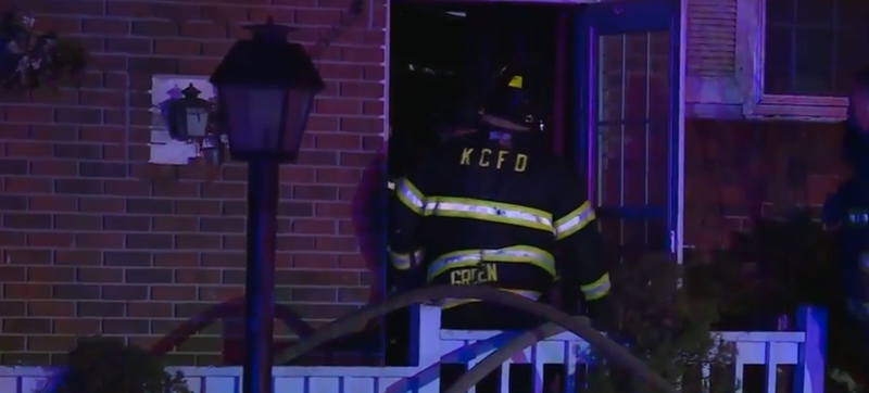 Firefighters investigate the scene of a house fire where a firefighter was hurt.