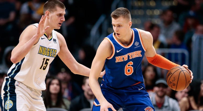 The Knicks' Kristaps Porzingis dribbles against the Nuggets' Nikola Jokic on Jan. 25, 2018 at the the Pepsi Center in Denver.