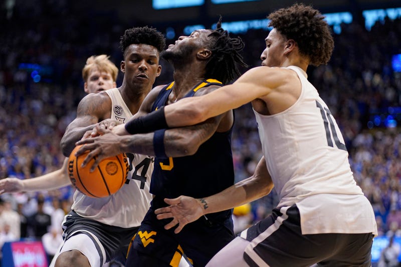  Joe Toussaint #5 of the West Virginia Mountaineers has the ball stripped away by K.J. Adams Jr. #24 and Jalen Wilson #10 of the Kansas Jayhawks in the second half at Allen Fieldhouse on February 25, 2023 in Lawrence, Kansas.