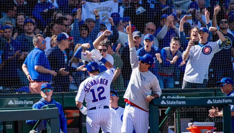 Outfielder Kyle Schwarber and the Cubs dugout celebrate after he hit a home run.