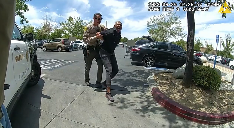 deputy pulling a woman's arms behind her back