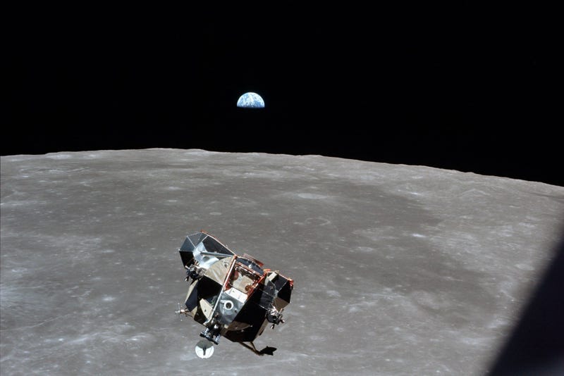 Astronaut Mike Collins captures Earth, the moon, the Eagle, and the edge of the Command Module's window in a single shot.