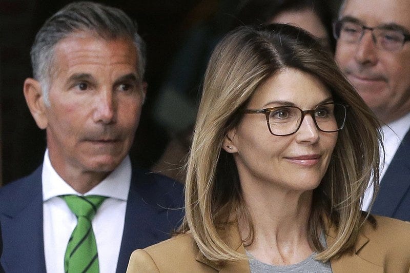 FILE - In this April 3, 2019 file photo, actor Lori Loughlin, front, and husband, clothing designer Mossimo Giannulli, left, depart federal court in Boston after facing charges in a nationwide college admissions bribery scandal. Loughlin was released from federal prison in Dublin, Calif., Monday, Dec. 28, 2020, after spending two months behind bars for paying half a million dollars in bribes to get her two daughters into college.