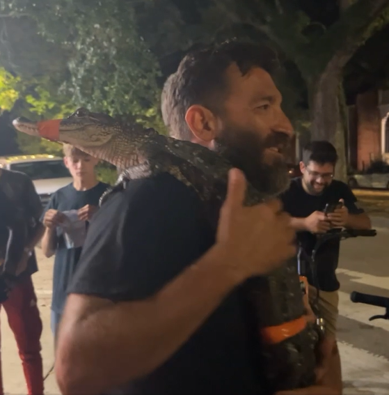 A man was photographed carrying a live alligator through the French Quarter in New Orleans, Louisiana on May 30, 2024.