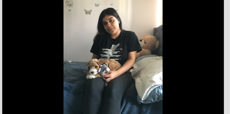 Priscilla Aguirre cuddles with Nico, the labradoodle puppy she received from the Make-A-Wish Foundation