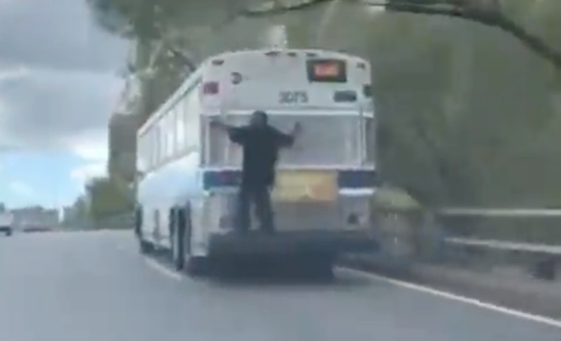 A man rides a bus down a New York City freeway