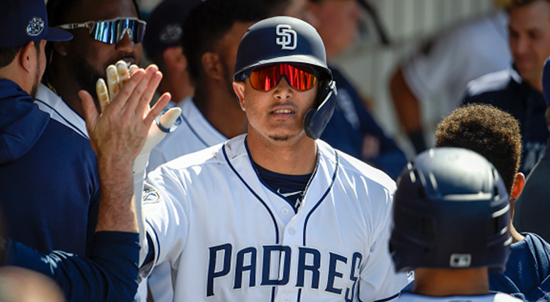 Manny Machado #13 of the San Diego Padres is congratulated in the dugout after hitting a two-run home run during the seventh inning of a baseball game against the Arizona Diamondbacks at Petco Park April 3, 2019 in San Diego, California. (Photo by Denis P