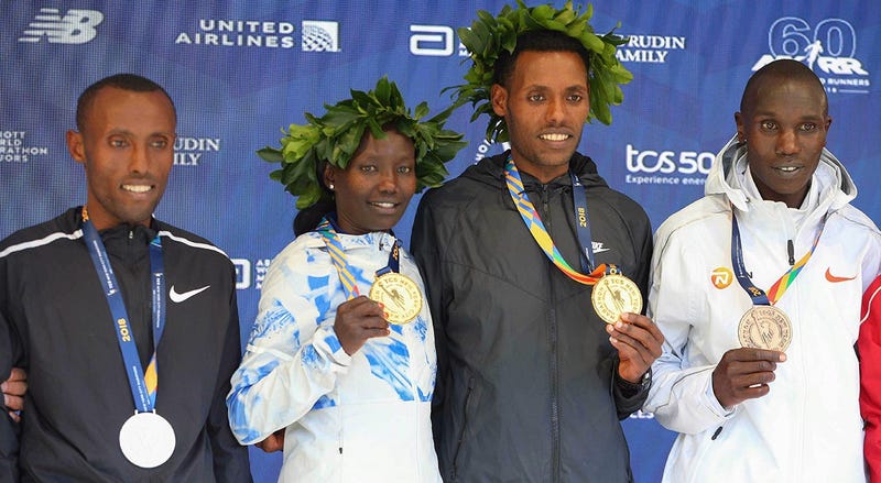 Nov 4, 2018; Lelisa Desisa of Ethiopia (center) and Mary Keitany of Kenya pose during the medal ceremony with Shura Kitata of Ethiopia (left) and Geoffrey Kamworor of Kenya (far right) after the New York City Marathon. Mandatory Credit: Vincent Carchietta