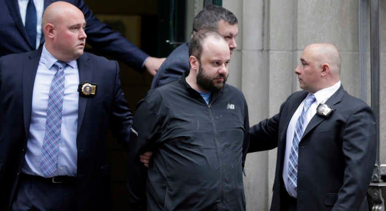 Marc Lamparello, 37, center, is escorted out of a police precinct in New York, Thursday, April 18, 2019.