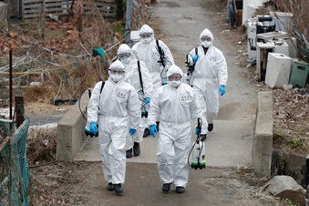 South Korean soldiers wearing protective gears walk to spray disinfectant as a precaution against the new coronavirus in Seoul, South Korea, Tuesday, March 3, 2020. (AP Photo/Lee Jin-man)