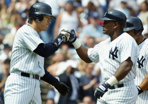 Hideki Matsui and Ruben Sierra celebrate a home run during a 2004 Yankees game. 