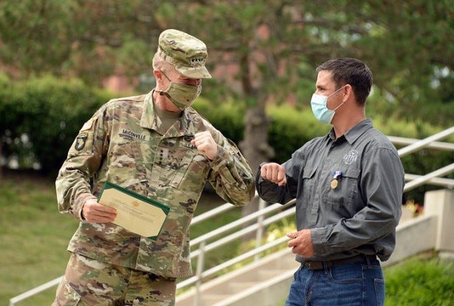 David Royer, right, exchanges an elbow bump with Chief of Staff of the Army Gen. James McConville