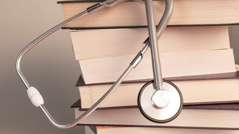 Concept of medical education with book and stethoscope - stock photo