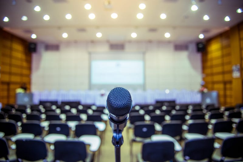 Microphone over the Abstract blurred photo of conference hall or seminar