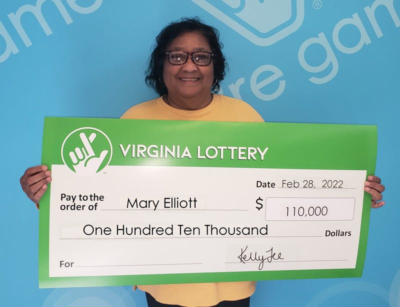 Mary Elliot holding a giant check