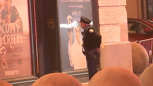 A police officer looks at a bullet hole left on the outside of The Met Philadelphia on March 6, 2024.