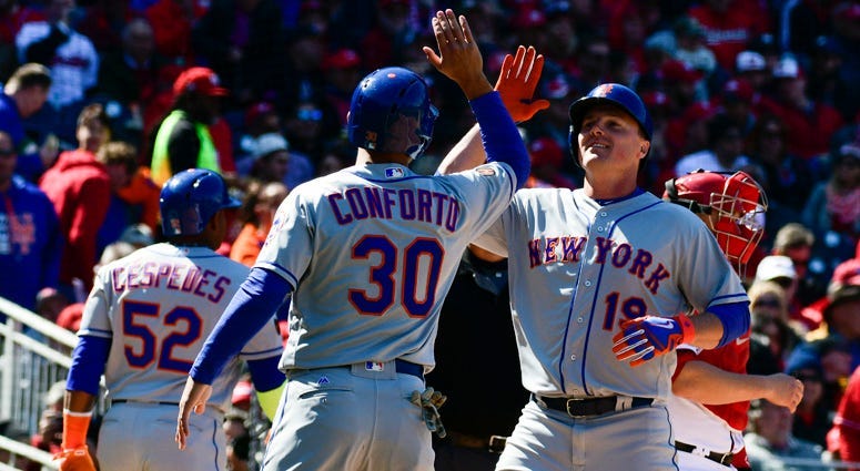 Mets right fielder Jay Bruce (19) high-fives Michael Conforto after hitting a grand slam against the Washington Nationals on April 5, 2018, at Nationals Park in Washington, D.C.