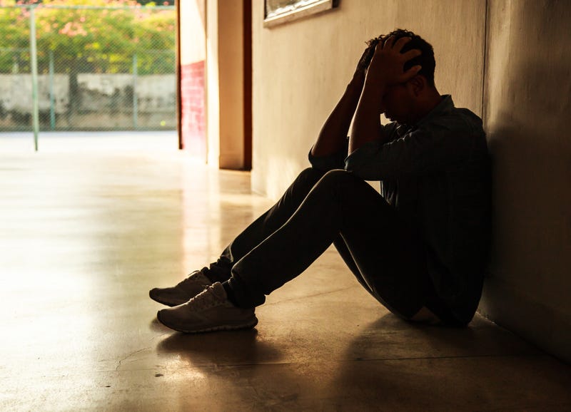 person sitting on floor in shadows