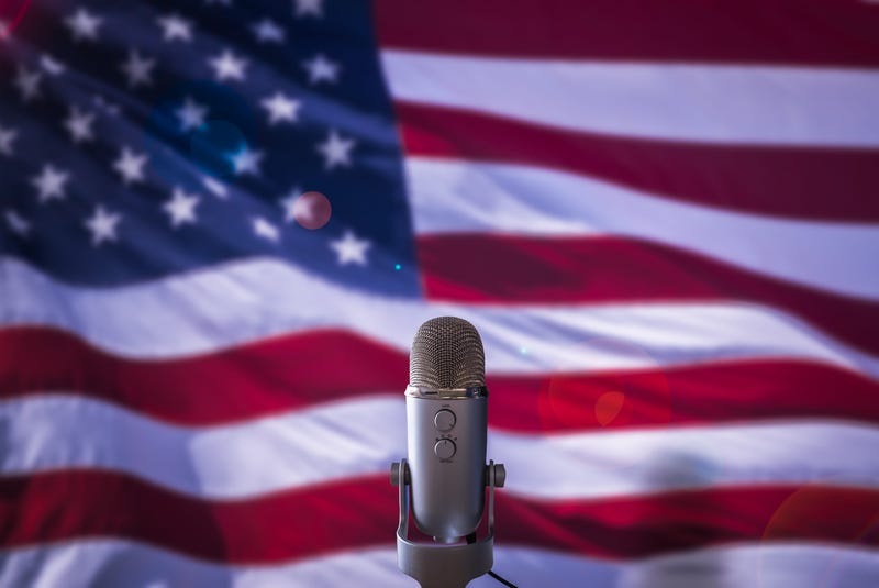 A microphone in front of a USA flag