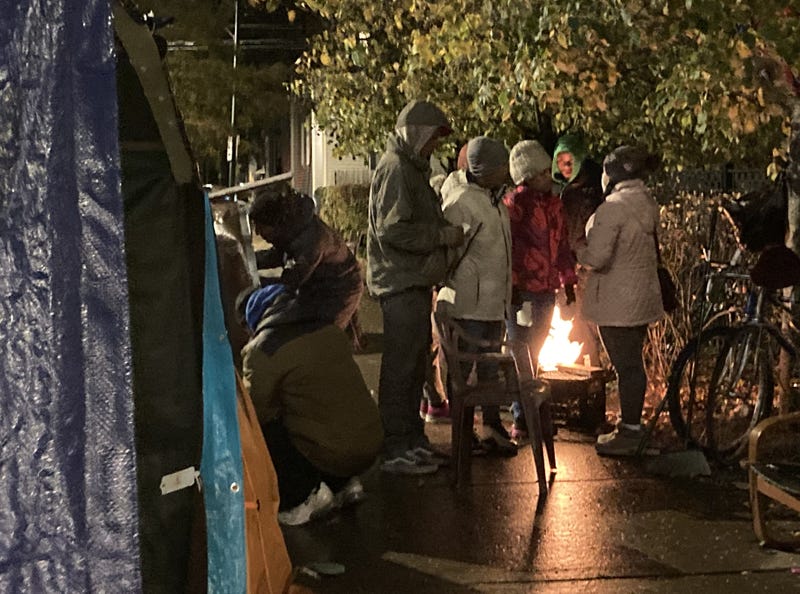 migrants standing over fire