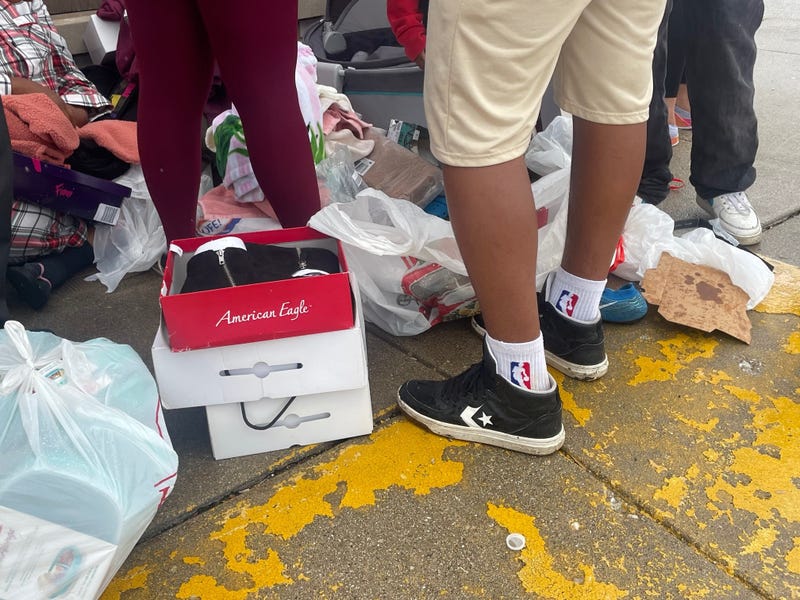 a picture of feet on pavement with shopping bags