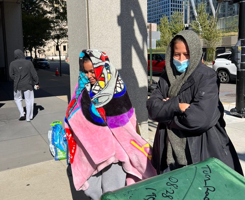 Two migrants with blankets and coats in Chicago