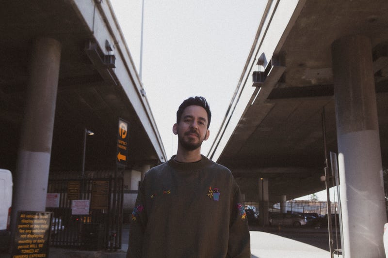 Singer/musician Mike Shinoda stands between and under two freeway on ramps