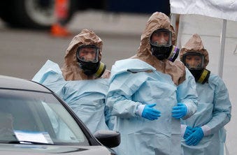 Colorado National Guard medical personnel prepare to perform coronavirus test on a motorist at a drive-thru testing site outside the Denver Coliseum Saturday, March 14, 2020, in Denver. (AP Photo/David Zalubowski)