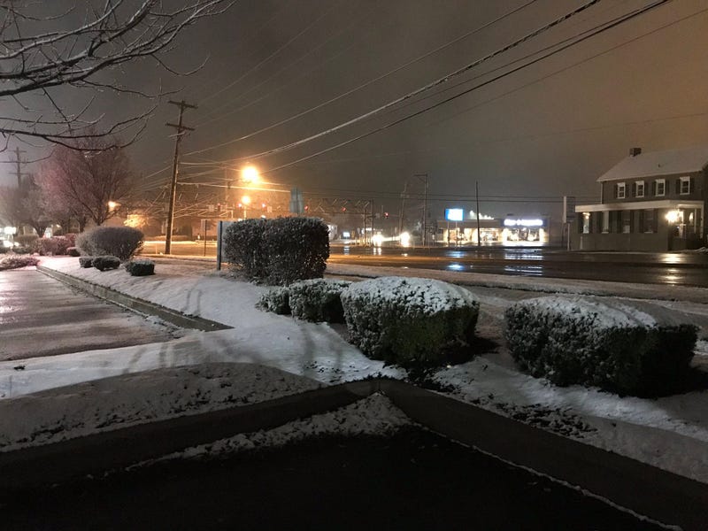 Snow sticks to the grass and bushes, but the roads are clear by the five points intersection in Montgomeryville, Pa.