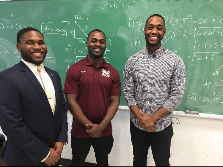 Nick Vaughn (l) captured the moment professor Nathan Alexander (r) babysat Wayne Hayer's (m) baby girl