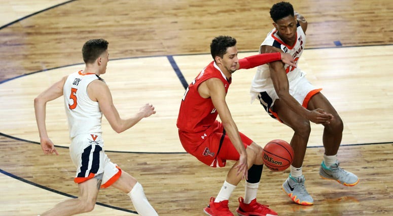Texas Tech guard Davide Moretti drives the ball up the court while pressured by Virginia guard De'Andre Hunter (12) and guard Kyle Guy (5) during the second half in the national championship game on April 8, 2019, in Minneapolis.