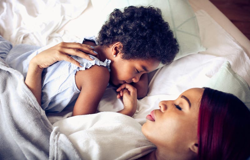 A mother sleeps next to her child