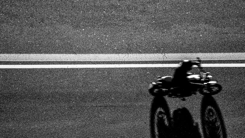 Top view of the Biker driving his motorcycle on the asphalt road